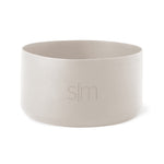 Pale cream-colored cylindrical vessel with soft gray interior walls against a neutral background.