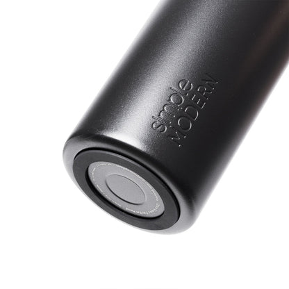 Matte black silicone drinkware with cylindrical shape and metallic base, monochromatic design with subtle gray tones