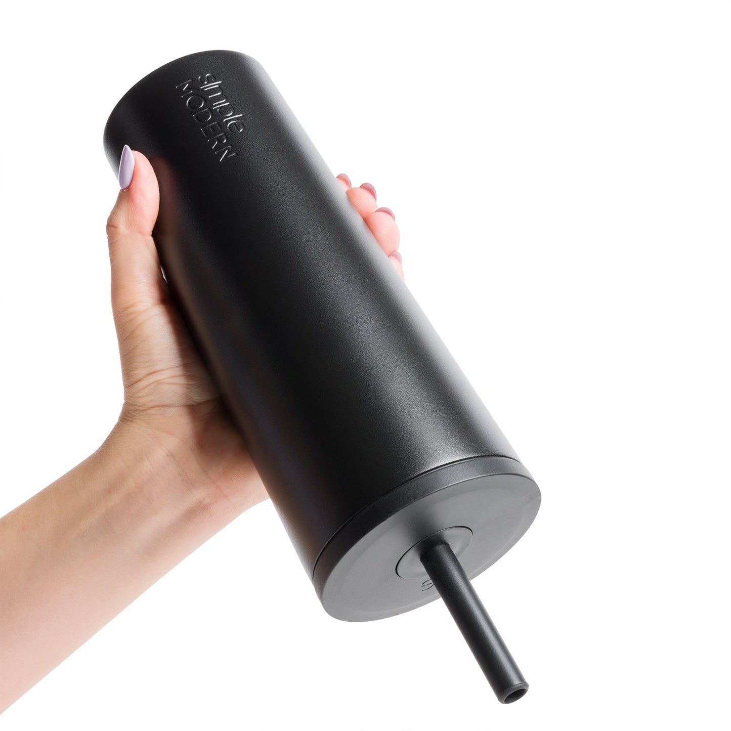 Black matte tumbler with gray base and accent ring held by a hand, white logo visible on cup