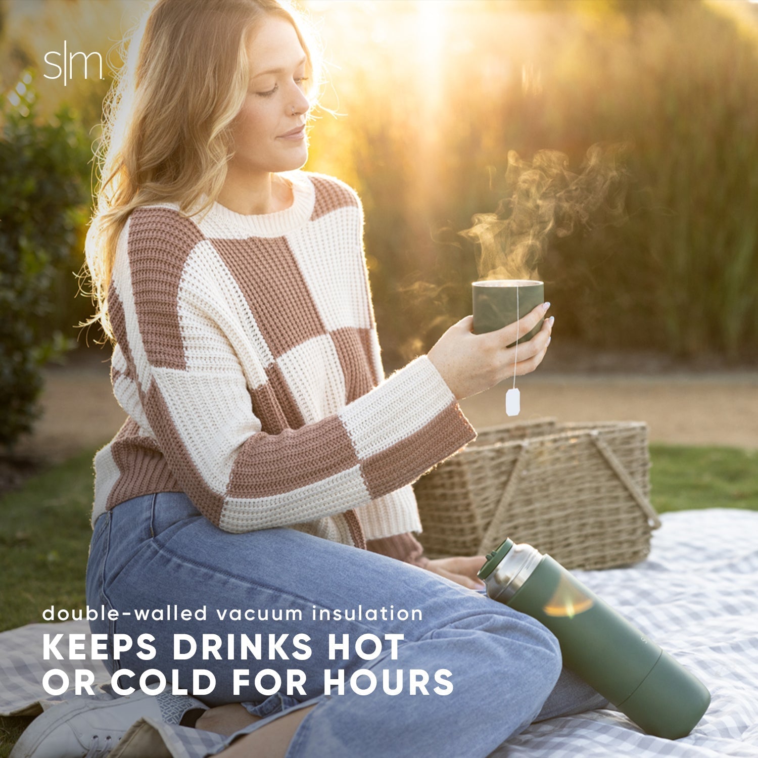 Insulated drinkware in forest green displayed against warm golden-hour lighting with soft beige, cream, tan, and brown earth-tone background.